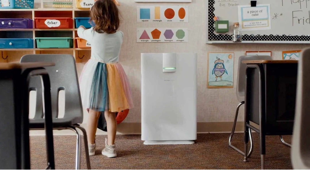 A child beside a Hathaspace purifier in a classroom